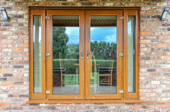 Wooden double doors with glass panels on brick wall