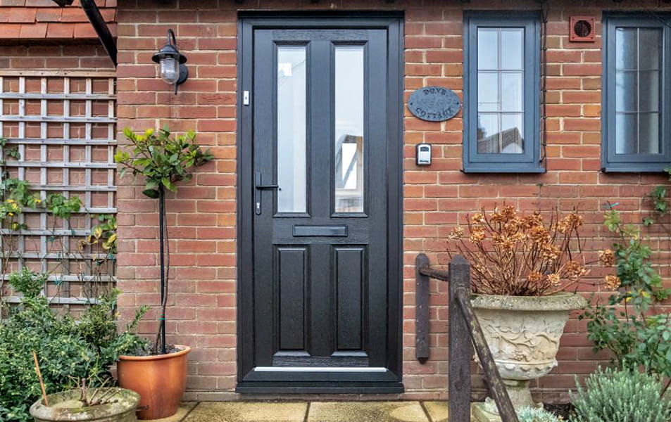 Black composite entrance door with glass panels and a black door furniture