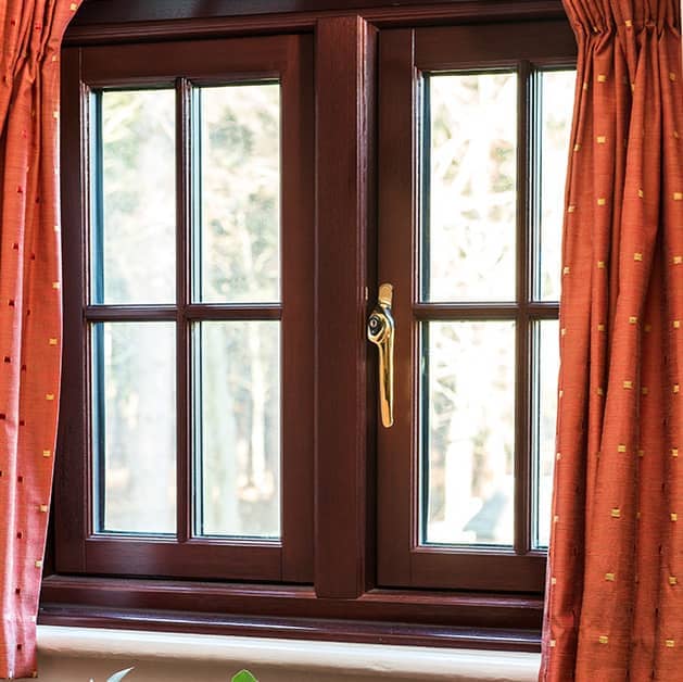 Brown Everest timber casement window with a gold modern handle