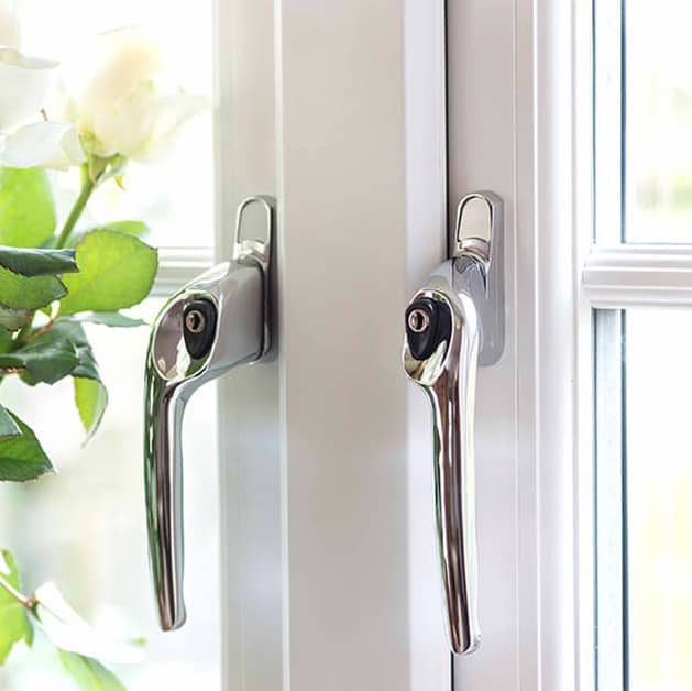 Close up of chrome modern handles on a white Everest uPVC casement window