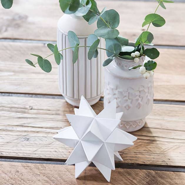 White vase with flowers on a table