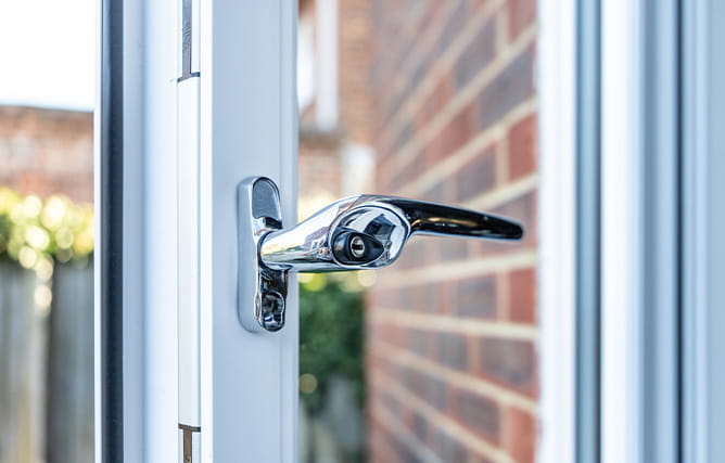 A white uPVC double glazed window with chrome handle and GrabLock from Yale