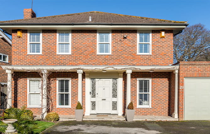 Front of a property with several white uPVC sash windows