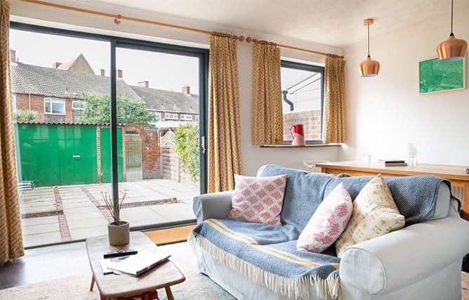 A cosy open plan living area with aluminium patio doors and aluminium windows