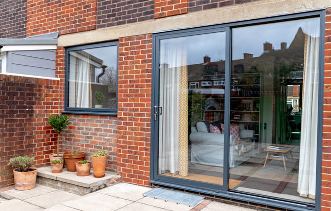 Matching aluminium window and sliding patio doors in black