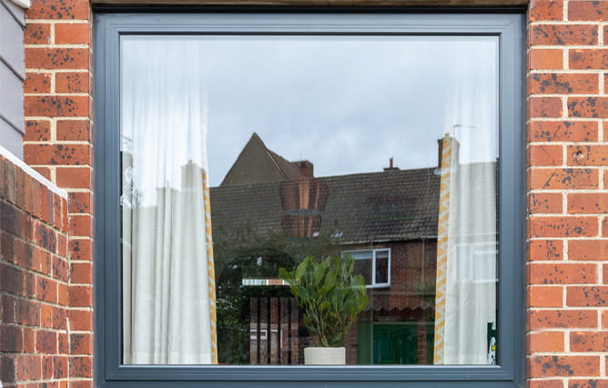 A aluminium slimline double glazed window on a traditional brick wall