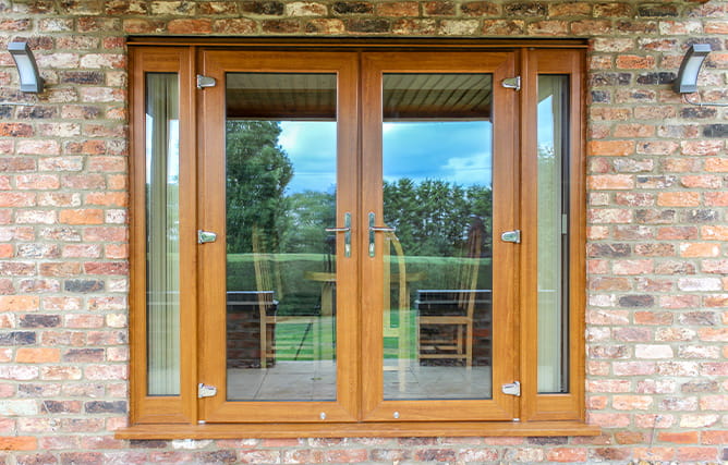 uPVC French doors in golden oak with side panels