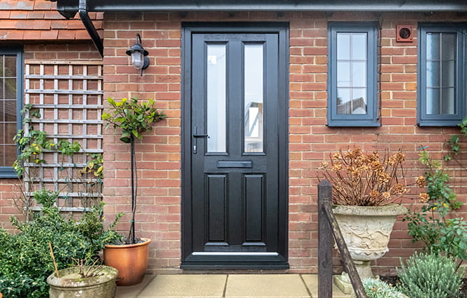 The front of a home with a black composite front door and matching aluminium windows