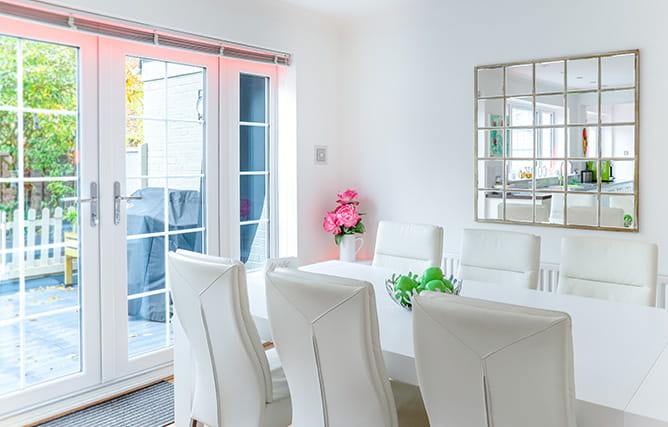 A set of white uPVC French doors with triple glazed panels and Georgian bars