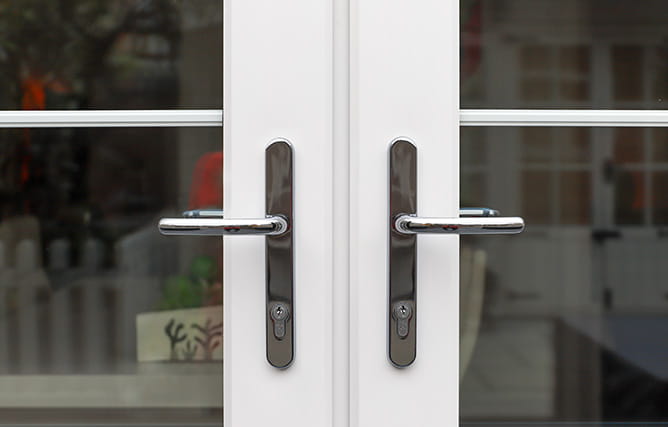 A view of French door handles in a chrome finish