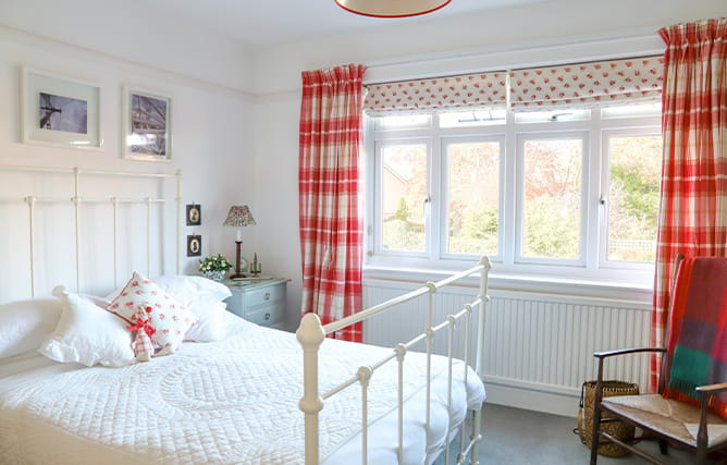 A bedroom with a large white uPVC casement window