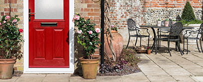 A red entrance door with half glazing panel