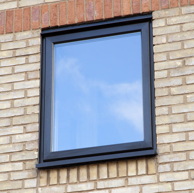 A black uPVC casement window on a brick house