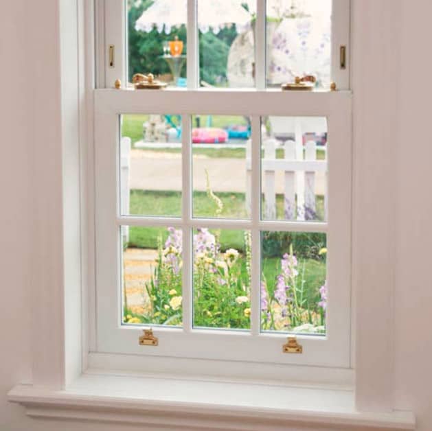 White uPVC sash window with Georgian bars and brass furniture