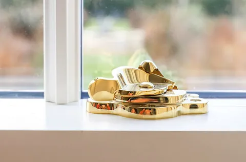 Gold window latch on white windowsill
