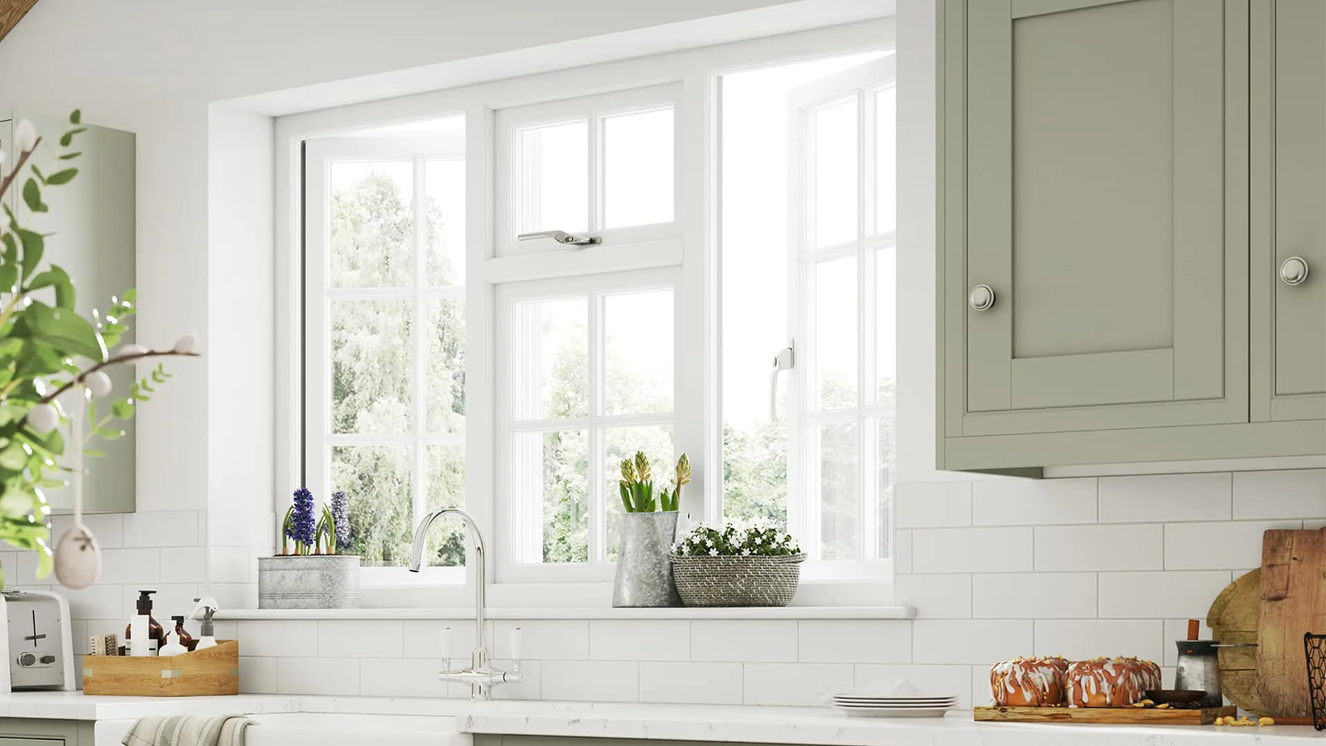 White window with sage green cabinets in a kitchen