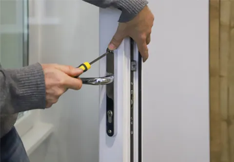 Someone fixing a white Everest door handle with screwdriver