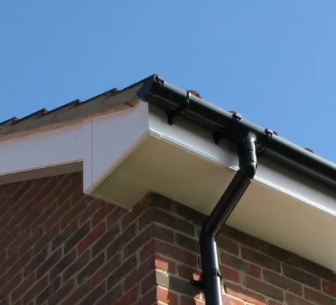 White conservatory roof edge with black gutters