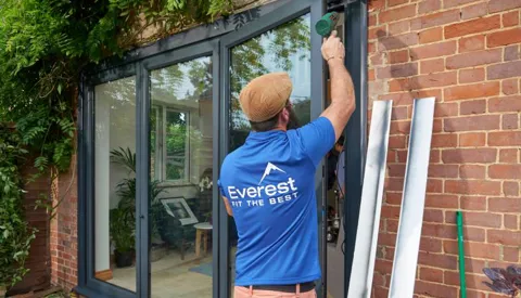 Everest conservatory installer working on a grey conservatory door