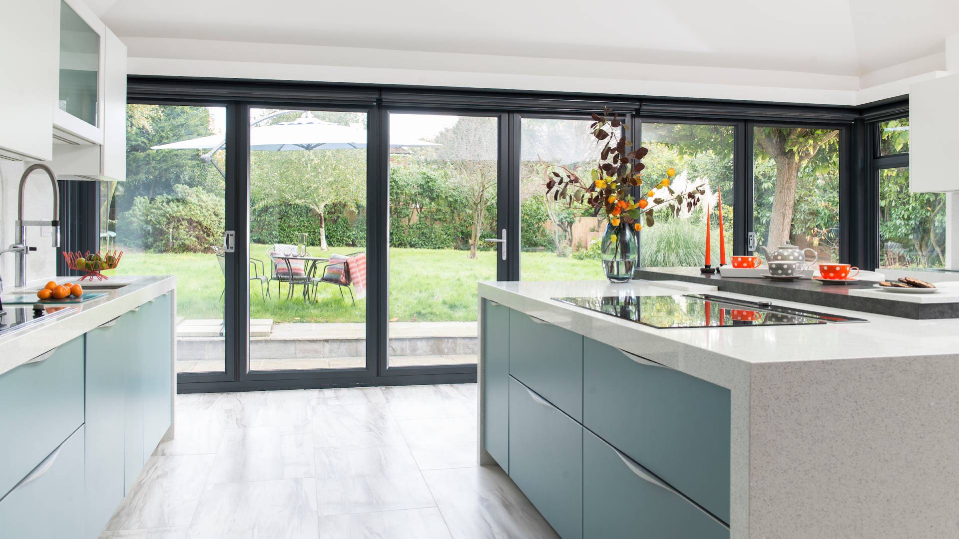 Everest conservatory kitchen with teal cabinets and garden view
