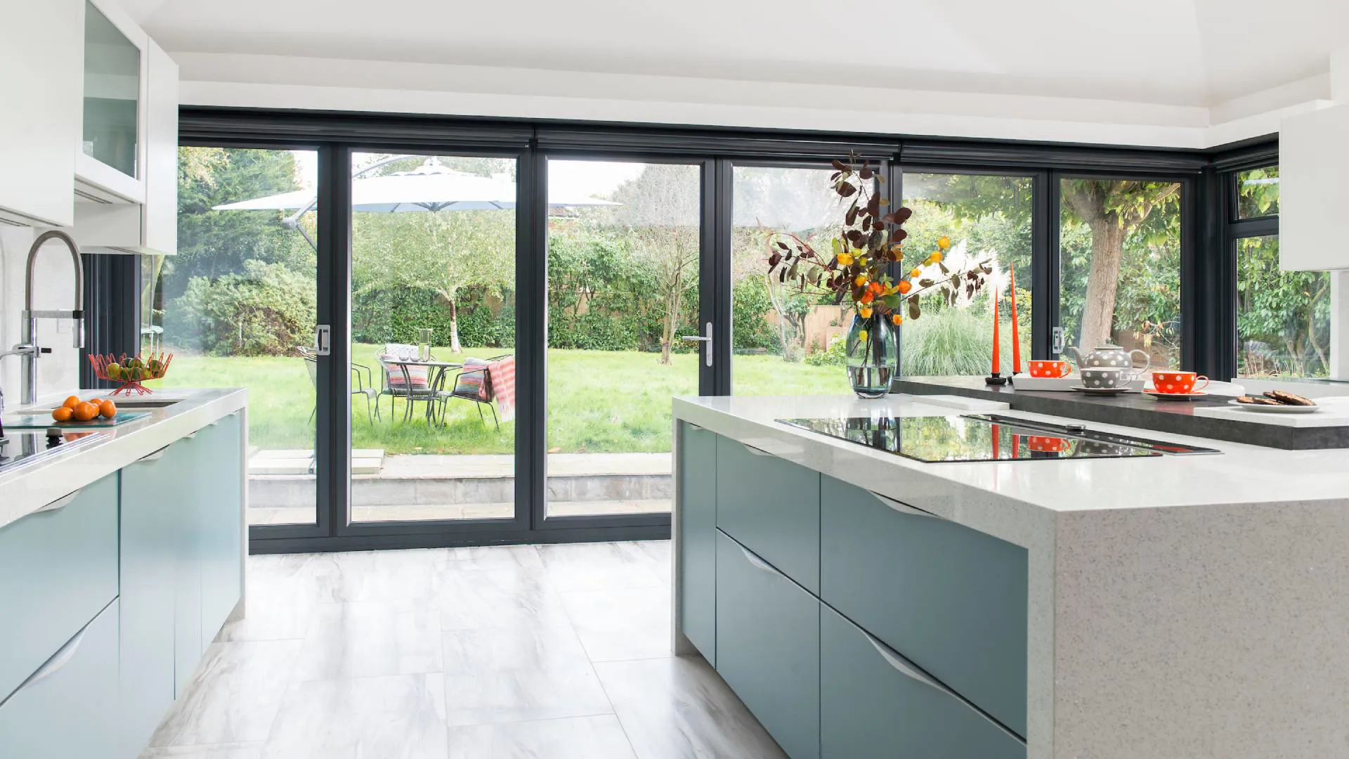 Everest conservatory kitchen with teal cabinets and garden view