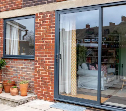 Everest conservatory with gray sliding doors and brick wall