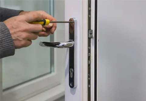 Person fixing a white Everest conservatory door handle with screwdriver