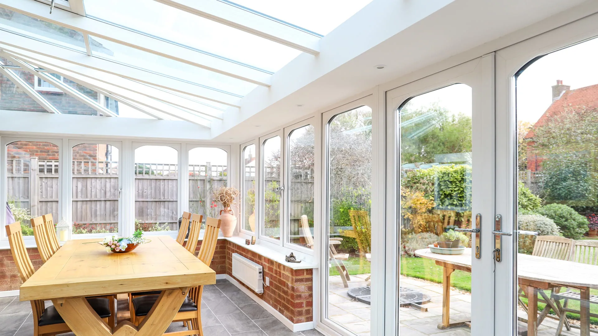White Everest conservatory with wooden dining table