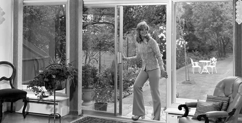 Woman opening Everest conservatory glass doors