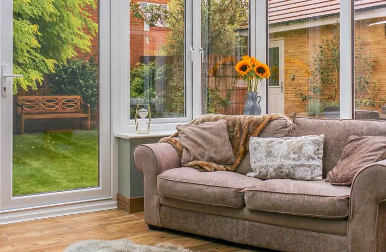 Everest conservatory with a taupe couch and sunflowers