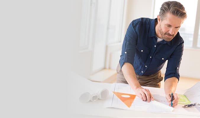 Man in blue shirt reviewing building plans