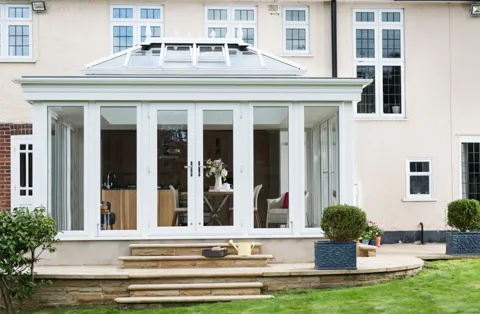 White Everest conservatory with large windows and stone steps
