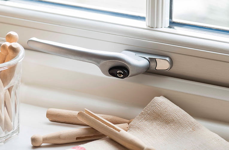 Silver window handle on a white Everest window