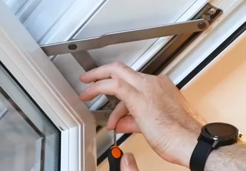 Person adjusting Everest conservatory window hinge with screwdriver