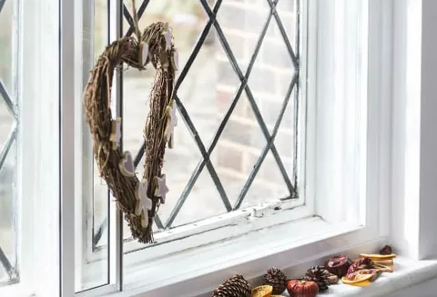 Heart shaped wreath with pastel decorations hanging on window