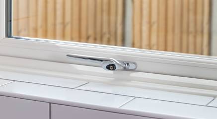 Inside of a white uPVC casement window with a chrome handle