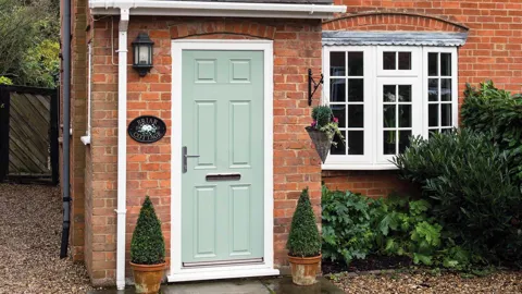 Light green Everest conservatory door with white trim and plants