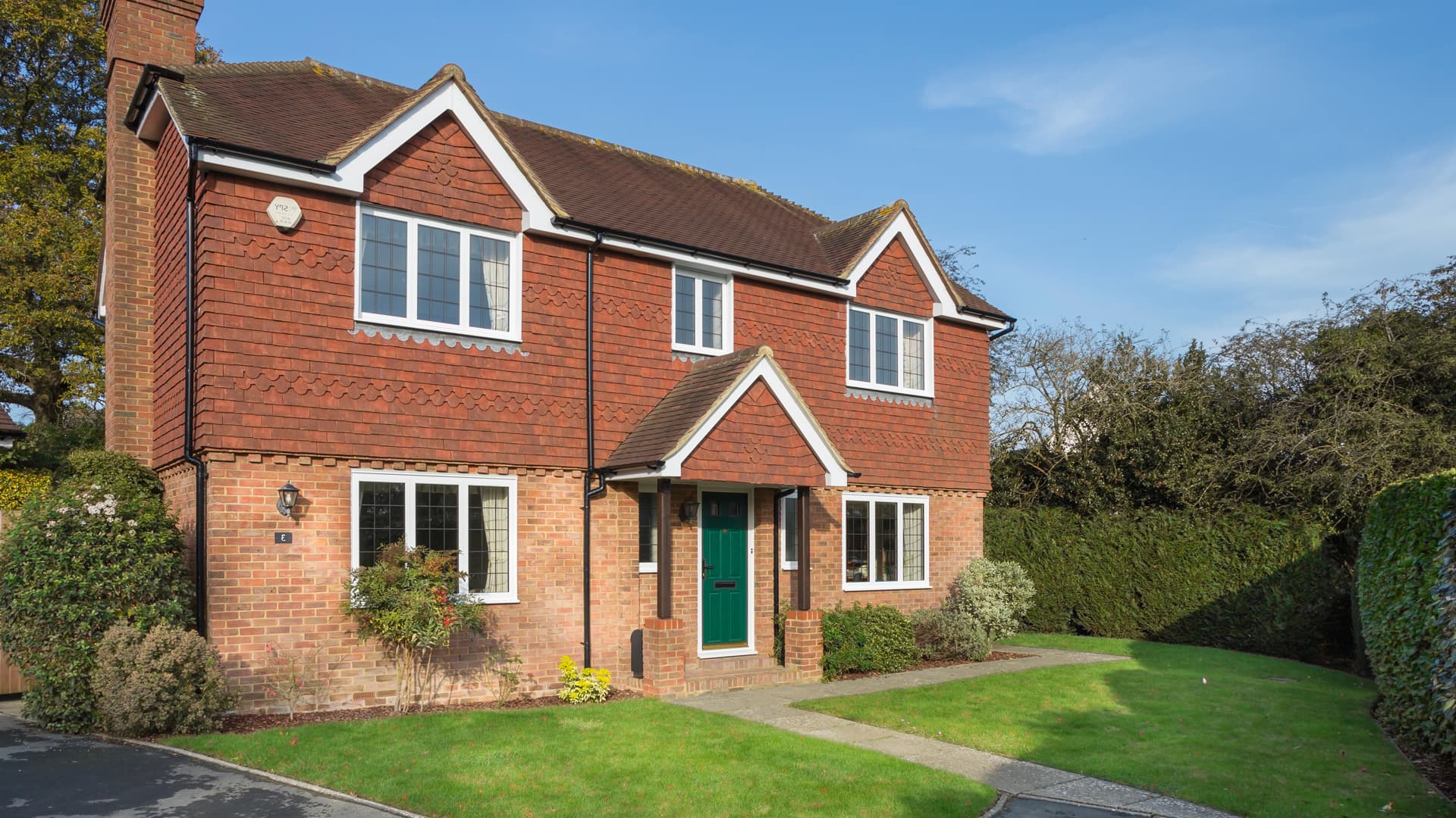Brick house with red tiled roof and white windows