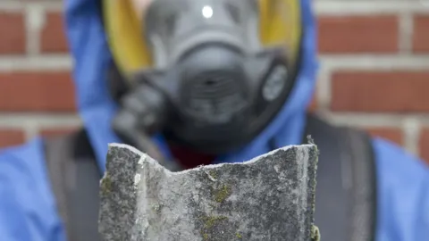 Damaged roof tile being held