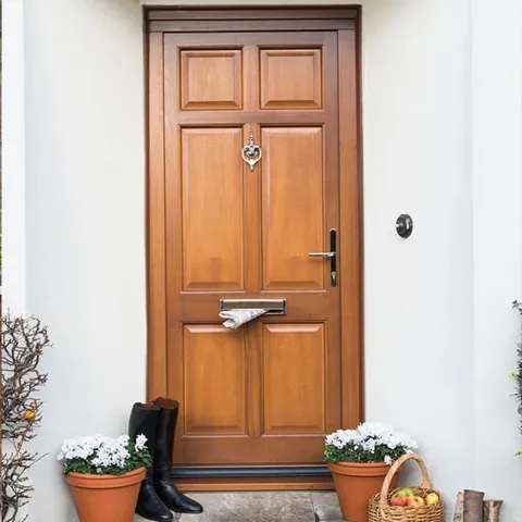 Light brown wooden front door with mail