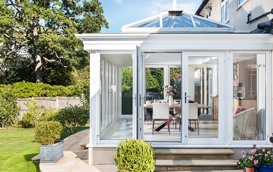 White Everest conservatory with glass roof and bi-fold doors