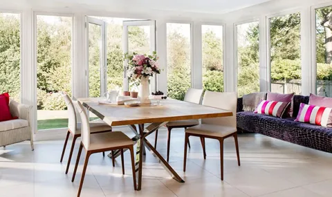Everest conservatory dining area with wooden table cream chairs and colorful cushions