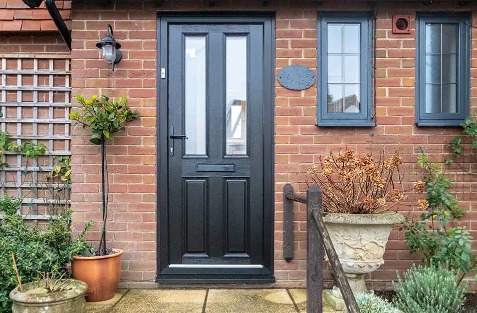 Black composite door on brick house exterior