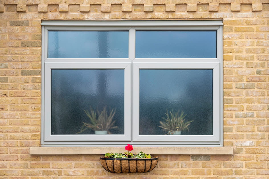 Grey Everest window on a yellow brick wall