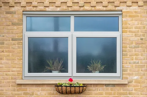 Grey Everest window on a yellow brick wall