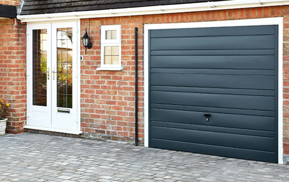 Dark grey garage door on brick house