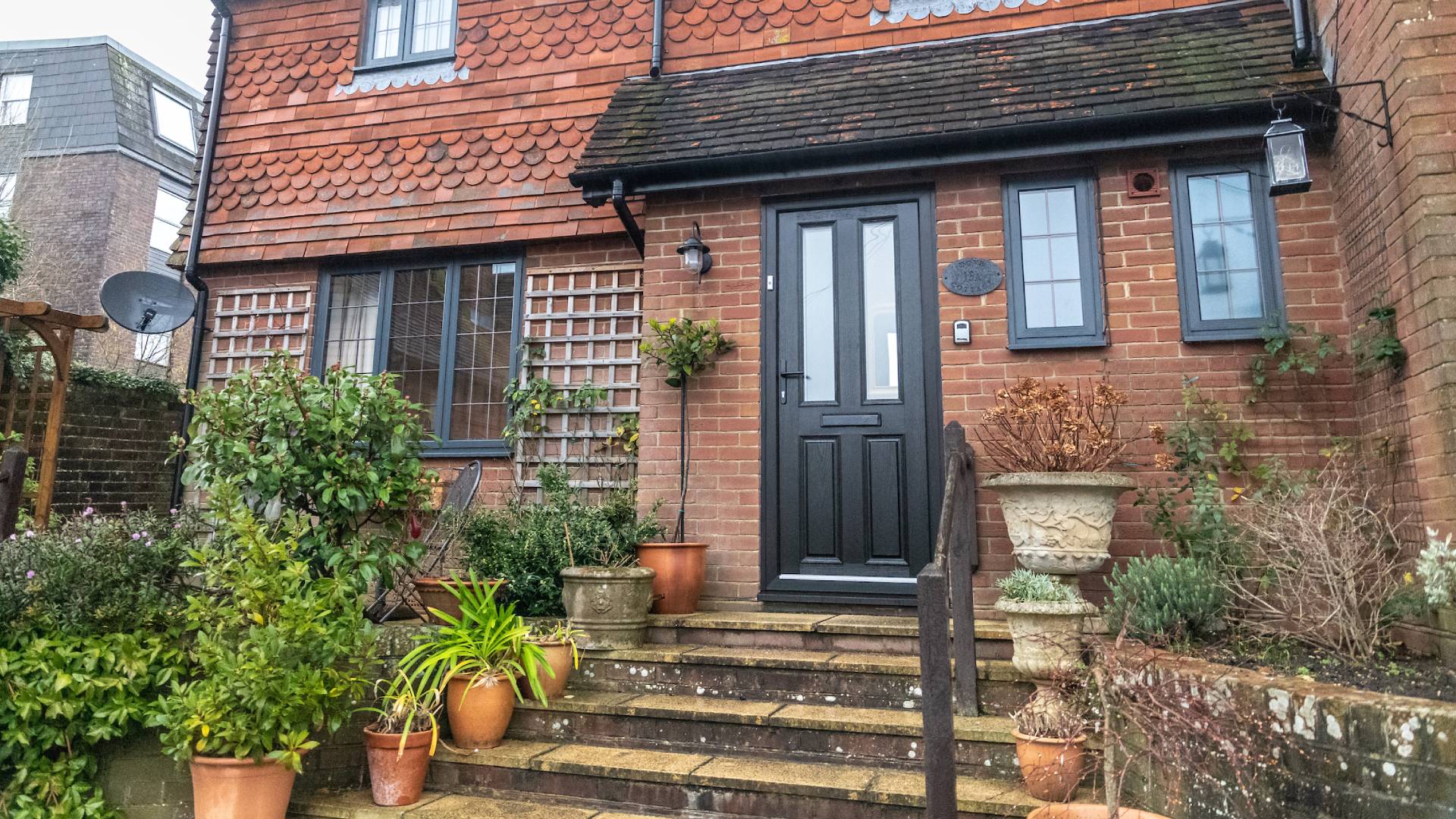 Black door with steps and plants