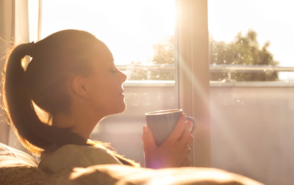 Woman enjoying a coffee by the window