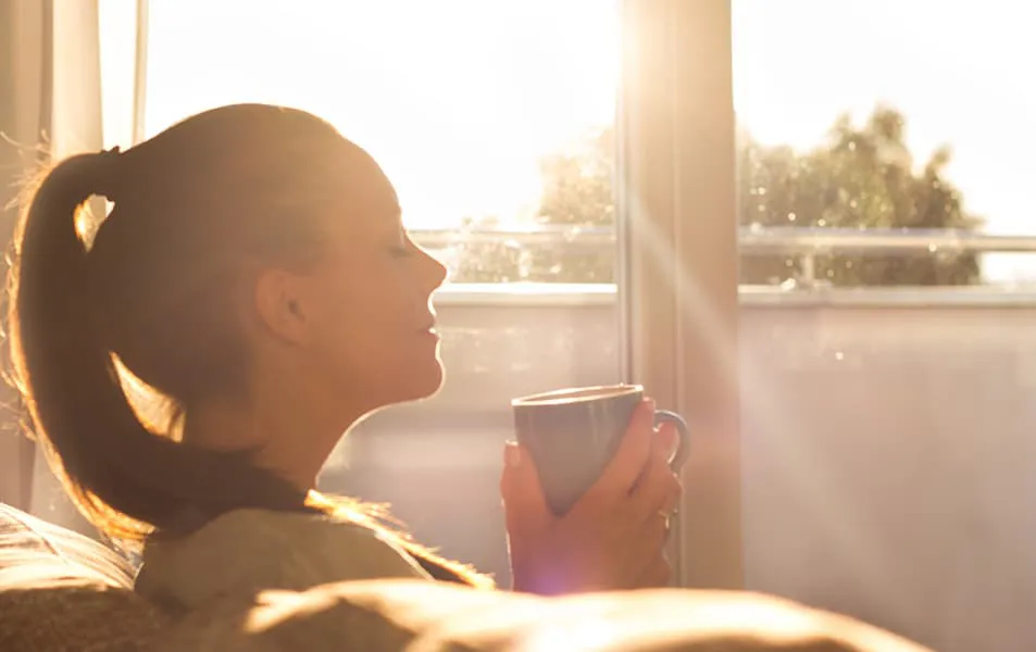 Woman enjoying a coffee by the window
