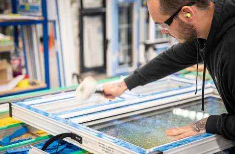Person cleaning Everest conservatory window frame
